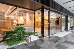 ein großes Glasgebäude mit einem Baum im Innenhof in der Unterkunft All Seasons Hotel Guangzhou Wuyangcun Metro Station in Guangzhou + 9 Fotos