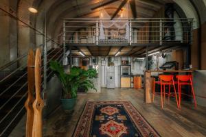 una cocina con un altillo con escalera y taburetes rojos en Hermosa Nests Industrial loft, en Playa Hermosa