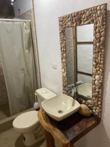 ein Badezimmer mit Waschbecken, Toilette und Spiegel in der Unterkunft Villa en Salango con piscina in Salango + 3 Fotos