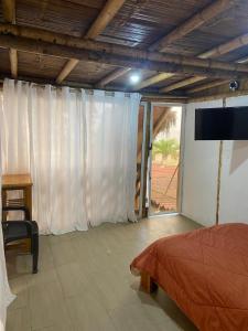 ein Schlafzimmer mit einem Bett und einem Flachbildfernseher in der Unterkunft Villa en Salango con piscina in Salango