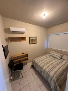 a bedroom with a bed and a projector screen at San Basilio Suites in Mexicali