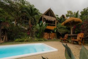 Un complejo con piscina y una casa. en Hermosa Nests Industrial loft, en Playa Hermosa