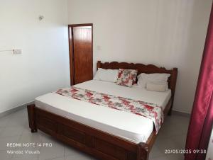 ein Schlafzimmer mit einem großen Bett mit weißer Bettwäsche in der Unterkunft Boutique Apartment in Nyali B6 in Mombasa