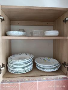 einen Stapel Teller und Schalen auf einem Regal in der Unterkunft Boutique Apartment in Nyali B6 in Mombasa