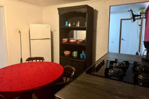 a kitchen with a red table and a refrigerator at SUITE 6, Centro de Cuauhtémoc Chihuahua in Cuauhtémoc