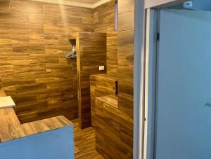 a bathroom with a shower with wooden walls at SUITE 6, Centro de Cuauhtémoc Chihuahua in Cuauhtémoc
