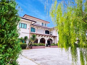 a large white house with trees in front of it at Villa 223 in Kajang