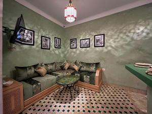 a living room with a couch and a table at Riad Lia ou Lik in Marrakesh