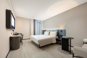 een hotelkamer met een bed en een televisie bij Atour Light Hotel Cixi Sports Center Xinhefang in Hushan