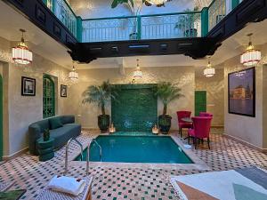 a swimming pool in a living room with a couch and chairs at Riad Lia ou Lik in Marrakesh