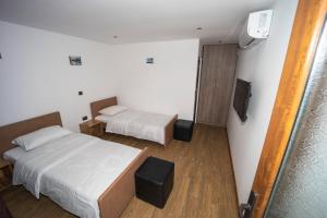 een hotelkamer met twee bedden en een televisie bij Banya Guest Rooms 23 in Banya +83 foto's