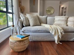 a living room with a couch and a table at The Little Beach Retreat - Relaxing family sized home one street from the sea! in Port Willunga