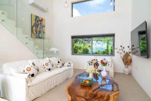 バーン・バンポーにある2br Tropical Villa Elisa Sea View Pool Breakfastの白いソファとテーブルのあるリビングルーム