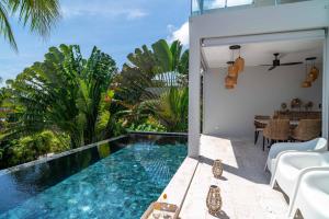 バーン・バンポーにある2br Tropical Villa Elisa Sea View Pool Breakfastのパティオ(スイミングプール、テーブル、椅子付)