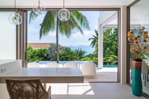 バーン・バンポーにある2br Tropical Villa Elisa Sea View Pool Breakfastのダイニングルーム(テーブル付)が備わり、海の景色を望めます。