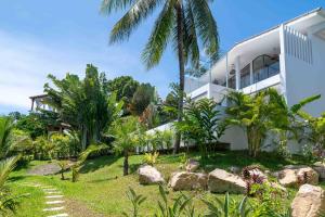 バーン・バンポーにある2br Tropical Villa Elisa Sea View Pool Breakfastのヤシの木と庭のある白い家