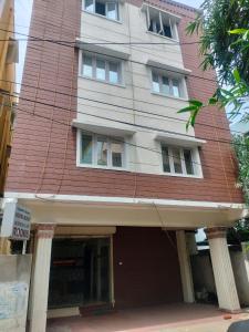 un grand bâtiment avec un toit rouge dans l'établissement Karuna Regent, à Chennai