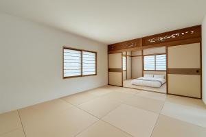 an empty room with a bed and two windows at The Lobs 4, 6BR 4BATH 8 mins to Rusutsu Brand new 2025 in Kimobetsu +9 photos