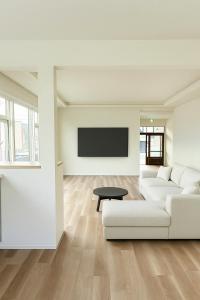 a living room with a white couch and a tv at The Lobs 4, 6BR 4BATH 8 mins to Rusutsu Brand new 2025 in Kimobetsu
