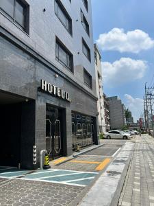 a hotel building on a city street with a fire hydrant at Hoteld Benikea in Osan