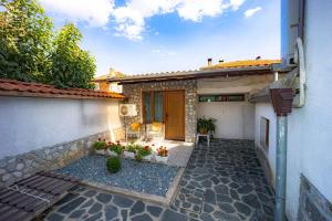 een huis met een patio met bloemen in een tuin bij Banya Guest Rooms 23 in Banya