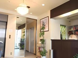 a lobby with a reception desk and potted plants at Hotel Akai in Tokyo