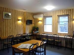 a dining room with wooden walls and tables and chairs at Business Hotel Tsuwano in Tsuwano