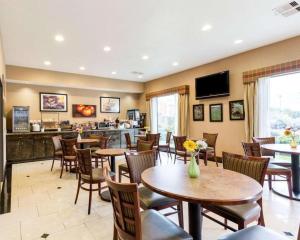 a restaurant with tables and chairs and a bar at Comfort Inn & Suites in Winnie