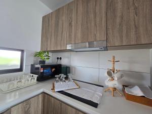 a kitchen with wooden cabinets and a counter top at Jenz-2 Homestay in Bintulu
