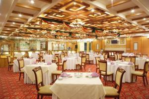 een eetkamer met witte tafels en stoelen bij Dongying Dongsheng Hotel in Kenli