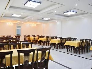 een lege banketzaal met tafels en stoelen bij Weihai Huayu Business Hotel in Weihai