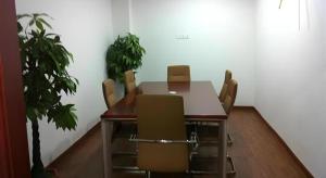 a conference room with a wooden table and chairs at GreenTree Inn Shanghai Songjiang Xinqiao Jiuxin Road Express Hotel in Chunshen
