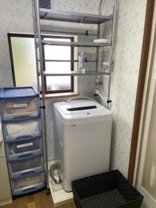 a small laundry room with a washer and a ladder at 湖を望む一軒家 in Wakasa