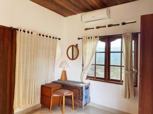 a room with a table and a chair and a window at Kapten Nyoman House in Saba