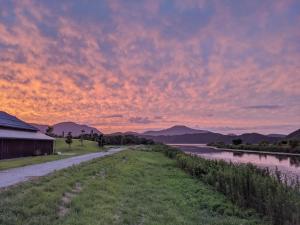 a sunset over a river with mountains in the background at 湖を望む一軒家 in Wakasa +13 photos