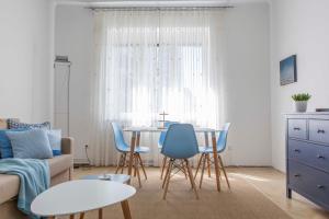 a living room with a table and blue chairs at Taya apartment in Ljubljana