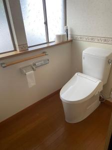 a white toilet in a bathroom with a window at 湖を望む一軒家 in Wakasa