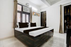 a bedroom with a large black and white bed at Collection O Sector 7 Rohini Formerly Giriraj Residency in New Delhi
