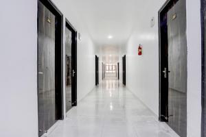 a hallway with black doors and white walls at Collection O Sector 7 Rohini Formerly Giriraj Residency in New Delhi