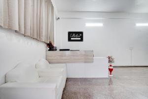 a white living room with a white couch and a table at Collection O Sector 7 Rohini Formerly Giriraj Residency in New Delhi