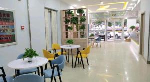 a restaurant with two tables and yellow chairs at 7 Days Inn Liaocheng Railway Station Dongchang Lake in Liaocheng
