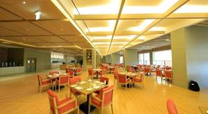 ソギポにあるJeju Booyoung Hotelのダイニングルーム(テーブル、赤い椅子付)