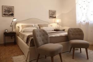 a bedroom with a bed and two chairs at Casa Fioravanti in Albinia