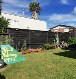 Hillpark Hideaway في أوكلاند: فناء خلفي مع علامة في العشب