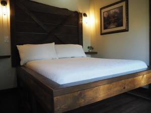 a bed with a wooden headboard in a room at La Arboleda in Lompoc