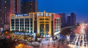 ein großes Gebäude in einer Stadt in der Nacht in der Unterkunft James Joyce Coffetel Xi'an Laochenggen Hongmiaopo Metro Station in Xi'an