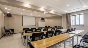 een klaslokaal met bureaus en stoelen en een whiteboard bij Xana Hotelle Suqian Soho Ginza Branch in Suqian