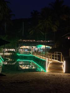 a swimming pool at night with green lights at Ourem Palace in Palolem