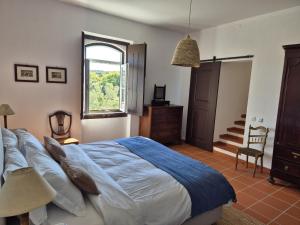 a bedroom with a large bed and a window at Herdade do Vidigal in Montemor-o-Novo +107 photos