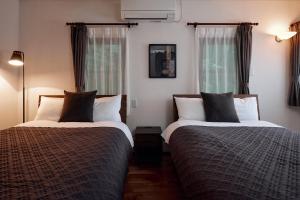 duas camas em um quarto com duas janelas em Noël Hakone Chimney em Hakone